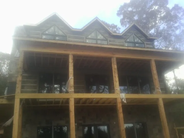 Dormers and porch framing on a large log home under construction — Roof Coating work by our crew in Elkview