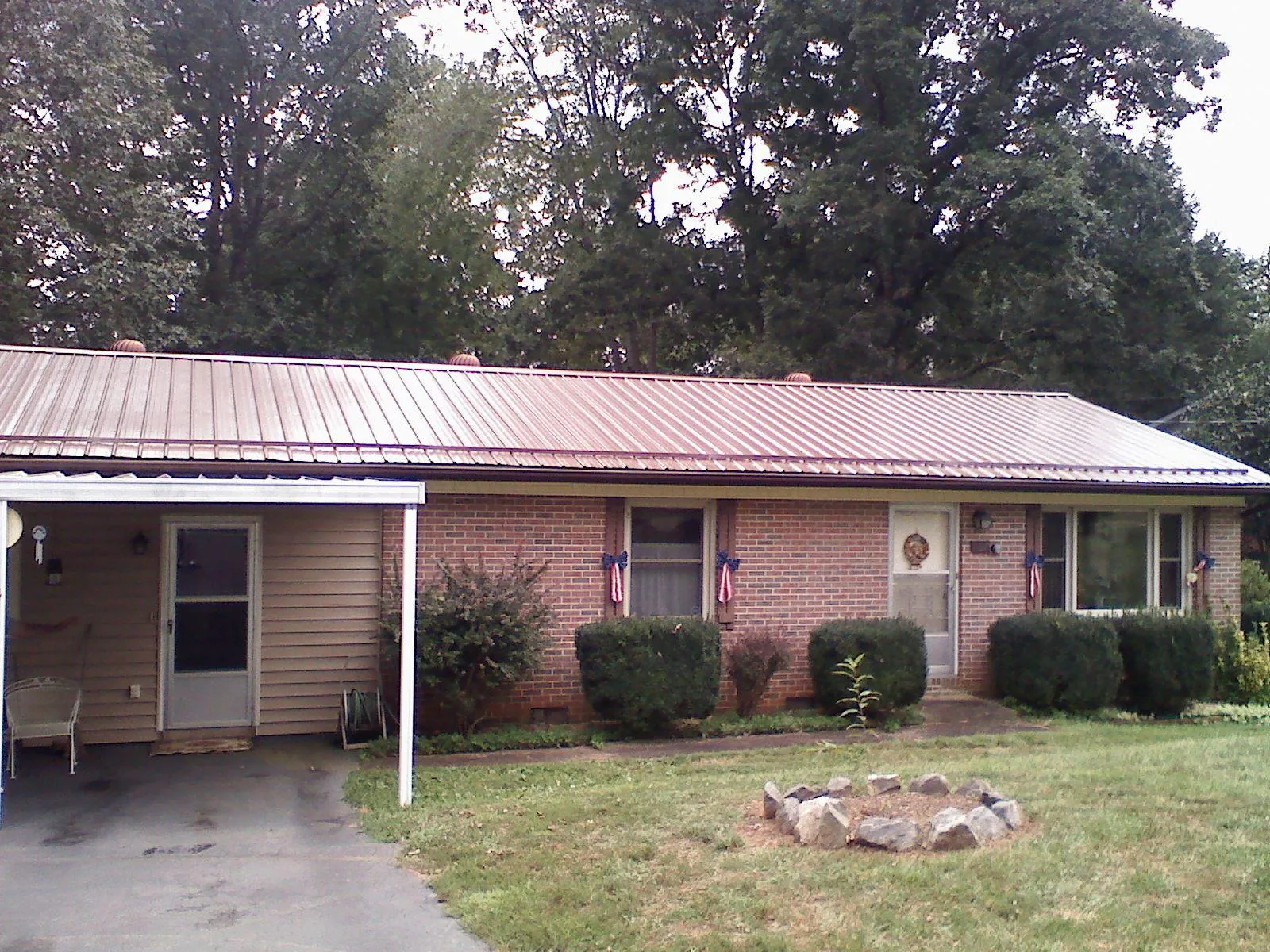 Bronze metal roof and carport on a brick ranch home — Roof Repair work by our crew in Elkview
